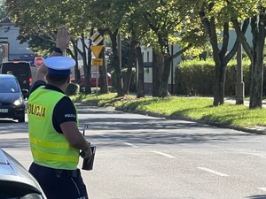 Policjant dający znak ręka kierowcy aby się zatrzymał.