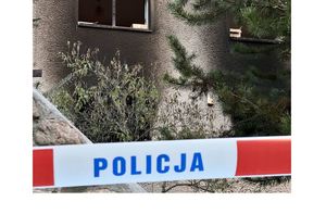 Na zdjęciu taśma z napisem POLICJa, w tle okno spalonej plebanii.