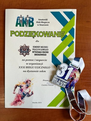 Na zdjęciu dyplom z podzelowaniami za pomoc w organizacji biegu. Oprócz dyplomu widzimy medal.