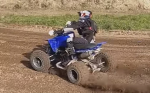 Na zdjęciu pędzący po błotnistej drodze quad