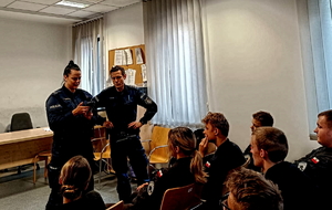 Na zdjęciu policjantka i policjant prowadzą wykład dla słuchaczy klasy mundurowej