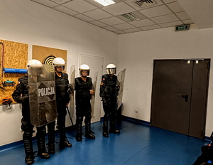 Na zdjęciu słuchacze przebrani w kaski policyjne i tarcze