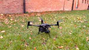 Na zdjęciu - stoi na trawniku policyjny dron