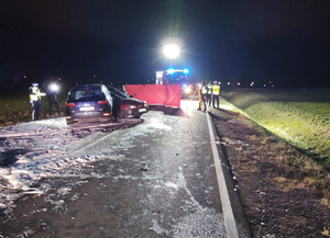 Na zdjęciu noc, miejsce wypadku drogowego widać rozbite dwa auta oraz policjantów pracujących na miejscu.