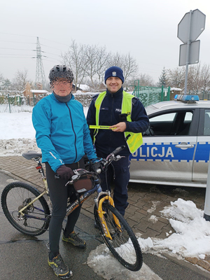 Na zdjęciu policjant drogówki wręcza odblask rowerzyście. Pozują doi zdjęcia.