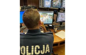 Na zdjęciu policjant patrzący w ekrany monitoringu miejskiego.