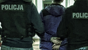 Na zdjęciu dwaj policjanci prowadzący między sobą młodego mężczyznę - skutego z tyłu kajdankami.