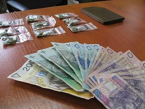 Na zdjęciu banknotu i woreczki z porcjami narkotyków.