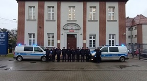 Na zdjęciu grupa policjantów w pozycji baczność na tle pyskowickiego komisariatu.