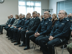 Na zdjęciu mundurowi i osoby cywilne patrzą w jeden punk na scenie - słuchają czyjejś przemowy.