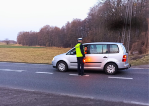 Na zdjęciu umundurowany policjant dokonujący badania stanu trzeźwości kierującego.