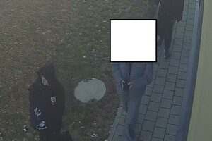 Młody mężczyzna w ciemnej kurtce z kapturem na głowie.