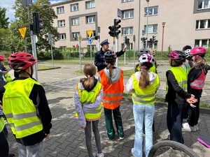 Stojący uczniowie na miasteczku ruchu drogowego stojący na miasteczku ruchu drogowego z policjantem