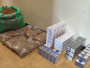 Na podłoże leżą kartony papierosów oraz worek tytoniu