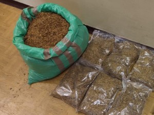 Na podłodze worek tytoniu i kartony papierosów