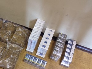 Na podłodze leżą worki tytoniu i kartony papierosów