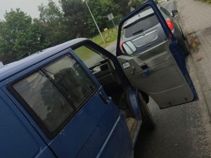 Granatowy pojazd VW z otwartymi drzwiami.
