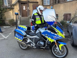 Umundurowany policjant stojący przy motocyklu