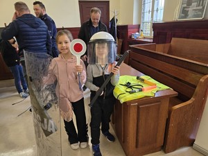 Dwoje dzieci stoją w kasku z tarczą ochronną i tarczą do zatrzymywania pojazdów