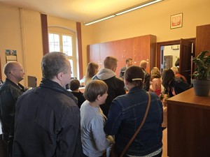 Grupa zwiedzających stoi na sali sądowej