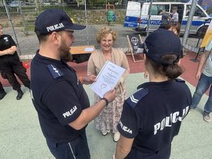 Dwoje umundurowanych policjantów stoi w towarzystwie Pani Dyrektor Ośrodka