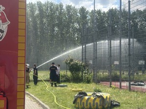 Obsługa węża gaśniczego. Młodzież leje wodę