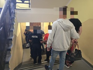 Zatrzymani prowadzeni przez policjantów schodzą po schodach kierując się do wyjścia