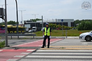 Umundurowany policjant wychodzi na skrzyżowanie do regulacji ruchem.