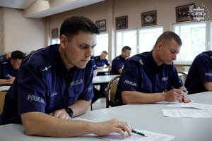 Zdjęcie przedstawia policjantów piszących test wiedzy