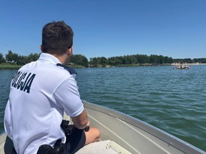 Policjant płynie po jeziorze w łódce