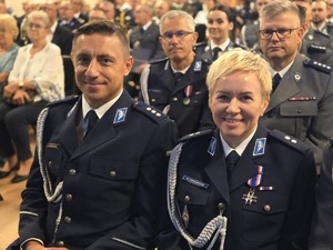 Policjant i policjantka w mundurach.