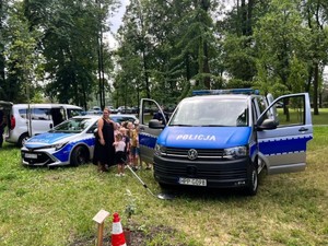 Dwa oznakowane radiowozy Policji na pikniku