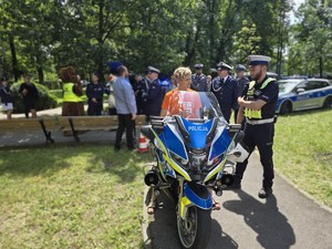 Na oznakowanym motocyklu policyjnym siedzi kobieta