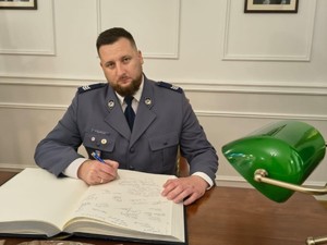 Sierż. szt. Paweł Maszczak dokonuje wpisu w księdze pamiątkowej.
