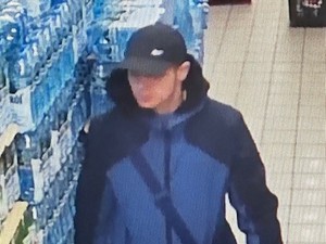 Mężczyzna w czapce bejsbolówce w sklepie przy półce