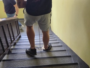 Na zdjęciu zatrzymany schodzi po schodach w kajdankach zespolonych