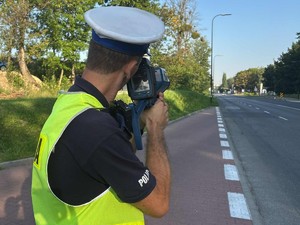 Policjant ruchu drogowego podczas pomiaru prędkości.