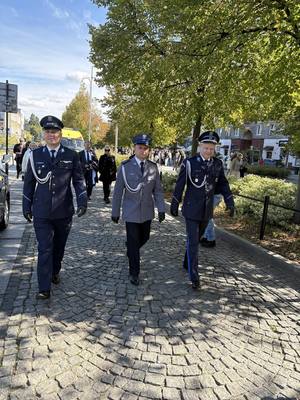 Trzech Policjantów w mundurze galowym idących na spotkanie na Jasna górę w Częstochowie.