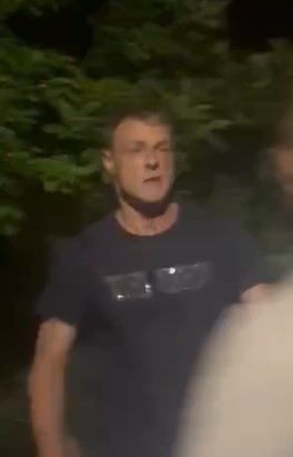 sprawca pobicia, ubrany w ciemny T-shirt