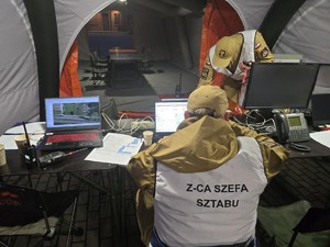 Wnętrze sztabu polowego i funkcjonariuszy dowodzących akcją.