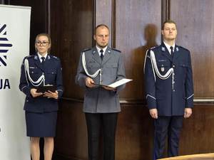 Na zdjęciu dwóch policjantów i policjanta w umundurowaniu służbowym prowadzący uroczystość