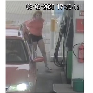 Na zdjęciu kobieta stojąca przy pojeździe na stacji paliw.