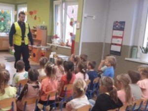 Na zdjęciu policjant ruchu drogowego prowadzący pogadankę w przedszkolu