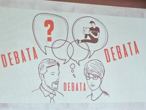 Slajd prezentacji wyświetlającej się na scenie z napisem &quot;Debata&quot;.