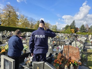 Policjanci oddają hołd zmarłemu policjantowi na grobie.