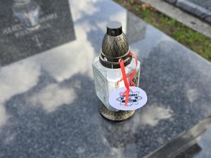Płonący znicz na pomniku.