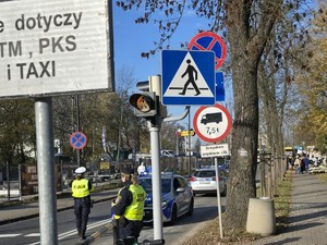 Na zdjęciu policjant ruchu drogowego oraz funkcjonariusz Straży Miejskiej podczas zabezpieczenia ruchu w rejonie cmentarza.