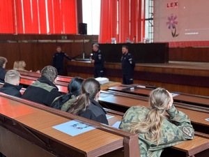 młodzież siedząca w ławkach na auli w Komendzie Miejskiej Policji w  Gliwicach - widok od tyłu