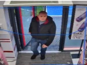 Na zdjęciu młody mężczyzna w krótkich włosach, ciemnej kurtce i ciemnych spodniach.