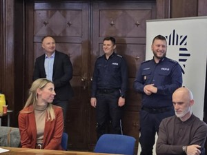 Dwoje policjantów prowadzących debatę przemawia do siedzących nauczycieli